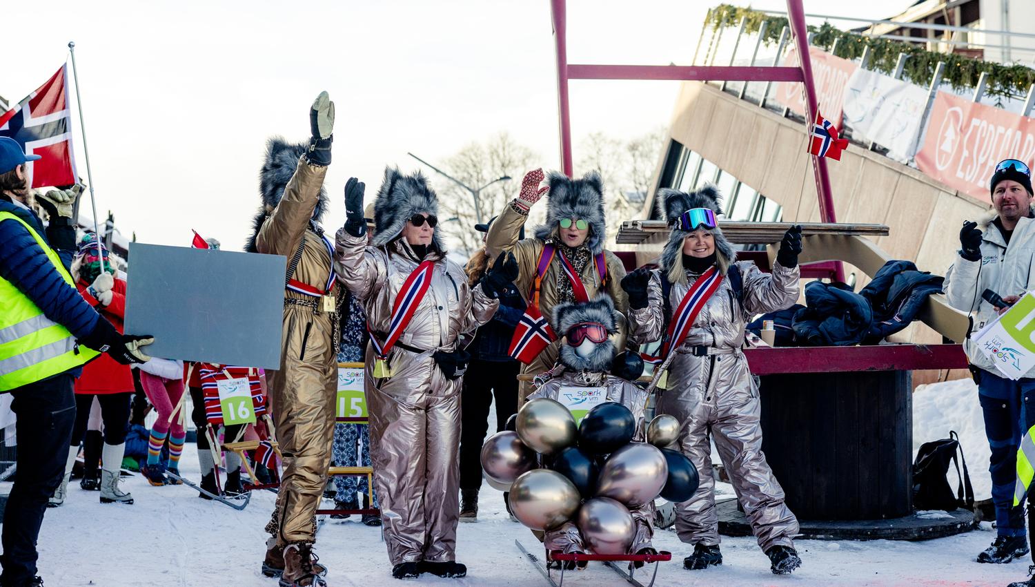 A large group of people participating in the Kicksled World Championship is sliding down the snow-