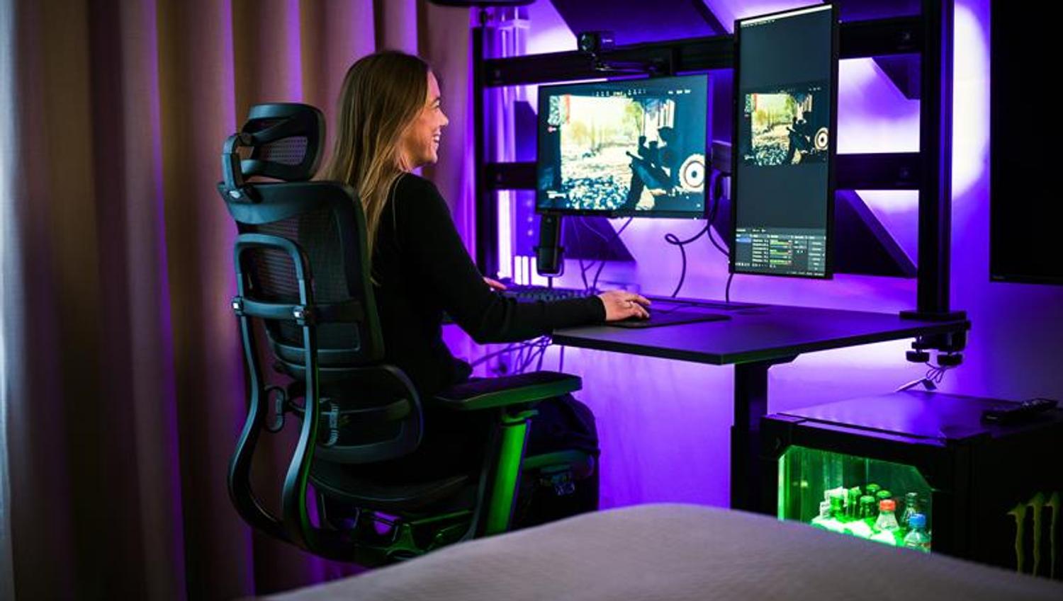 Female gamer in a chair in front of several screens gaming