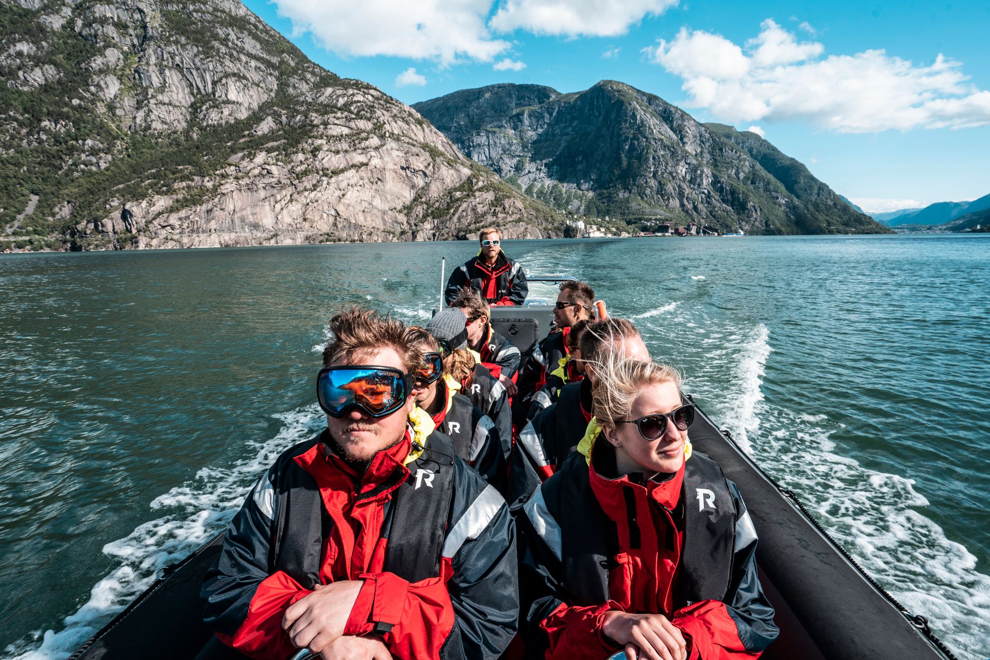 Adventurous tourists on a RIB safari surrounded by Norway’s raw nature.