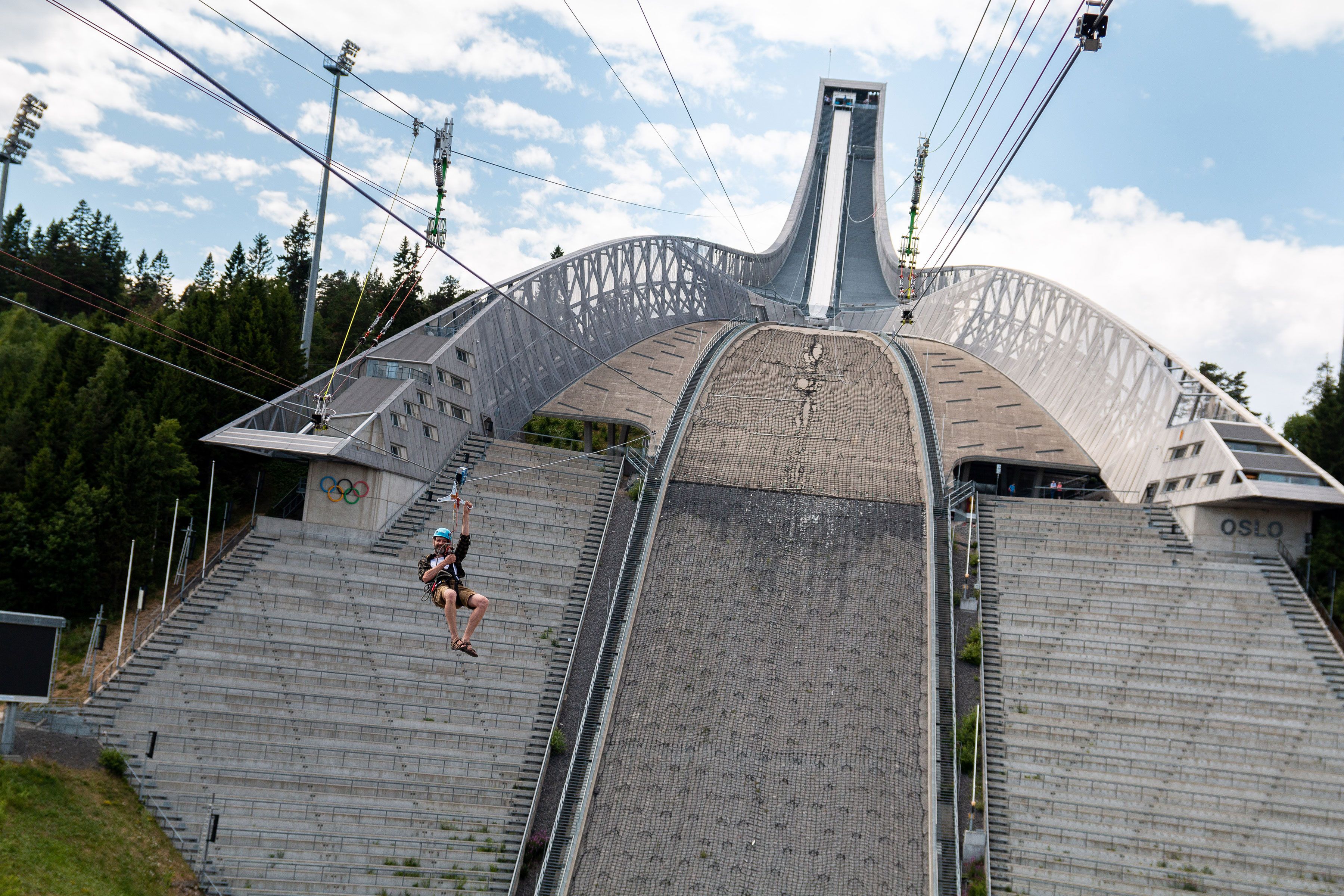 En person som zipliner nedover Holmenkollbakken.