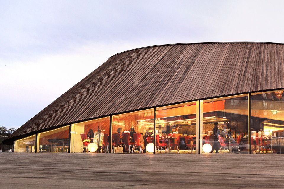 Eksteriørbilde av brun restaurant med store vinduer.