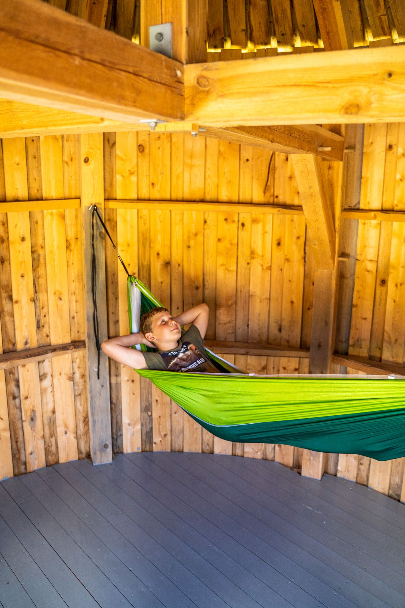 Gutt i hengekøye inni en hytte