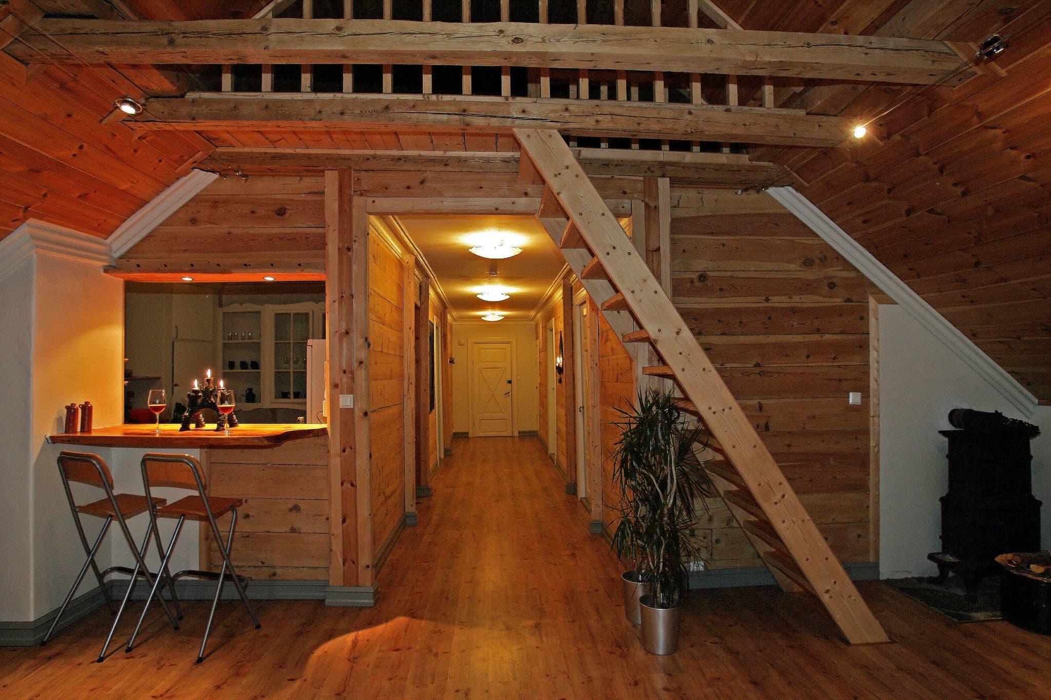 Lys og triveleg fellesstove på Vikinghaug Apartments med treinteriør, barløysing og open trapp, ideell for sosiale kveldar.