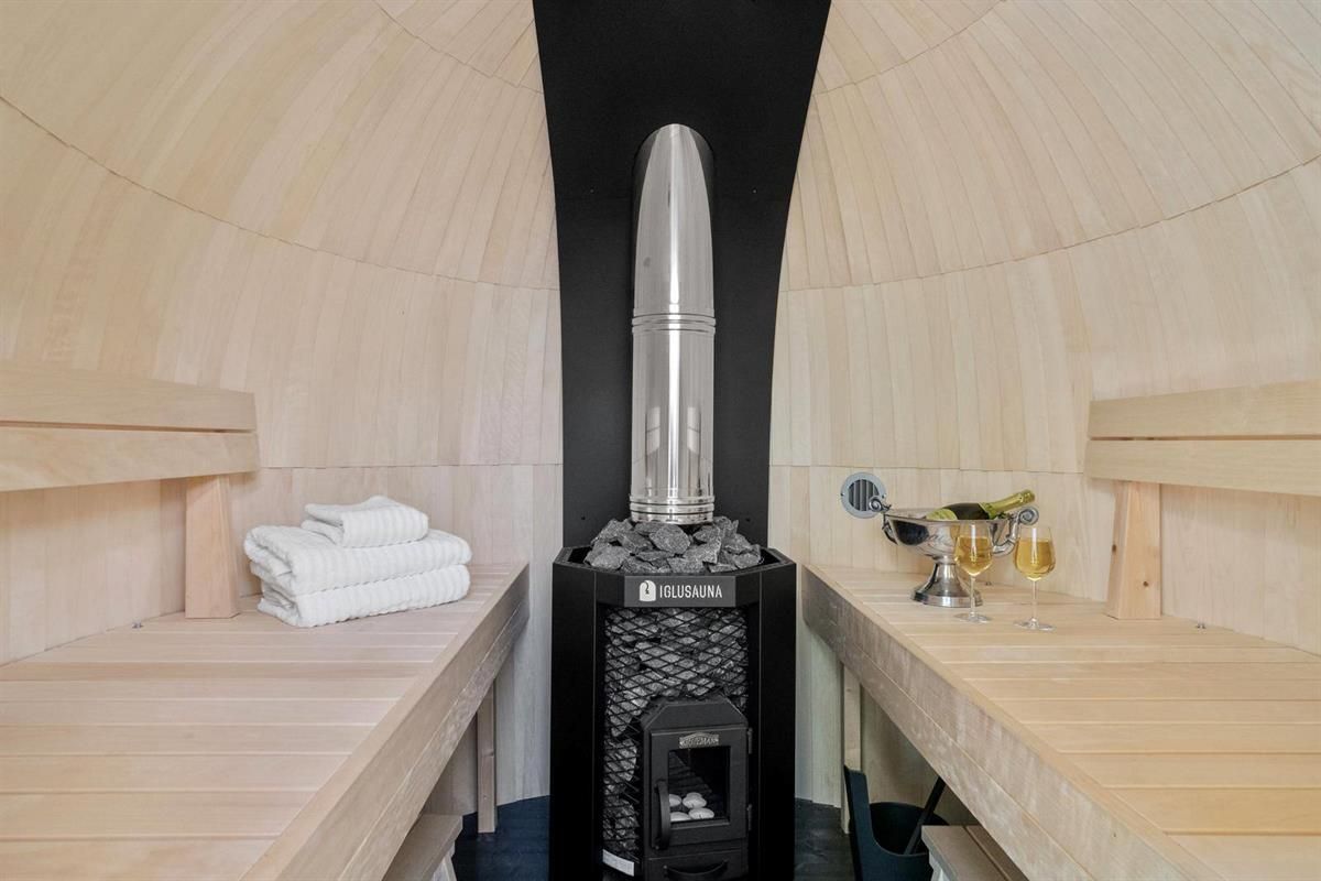  Interior of a barrel sauna with wooden benches and a central stove.