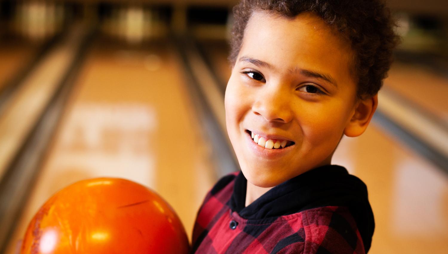Boy with bowling ball in hand