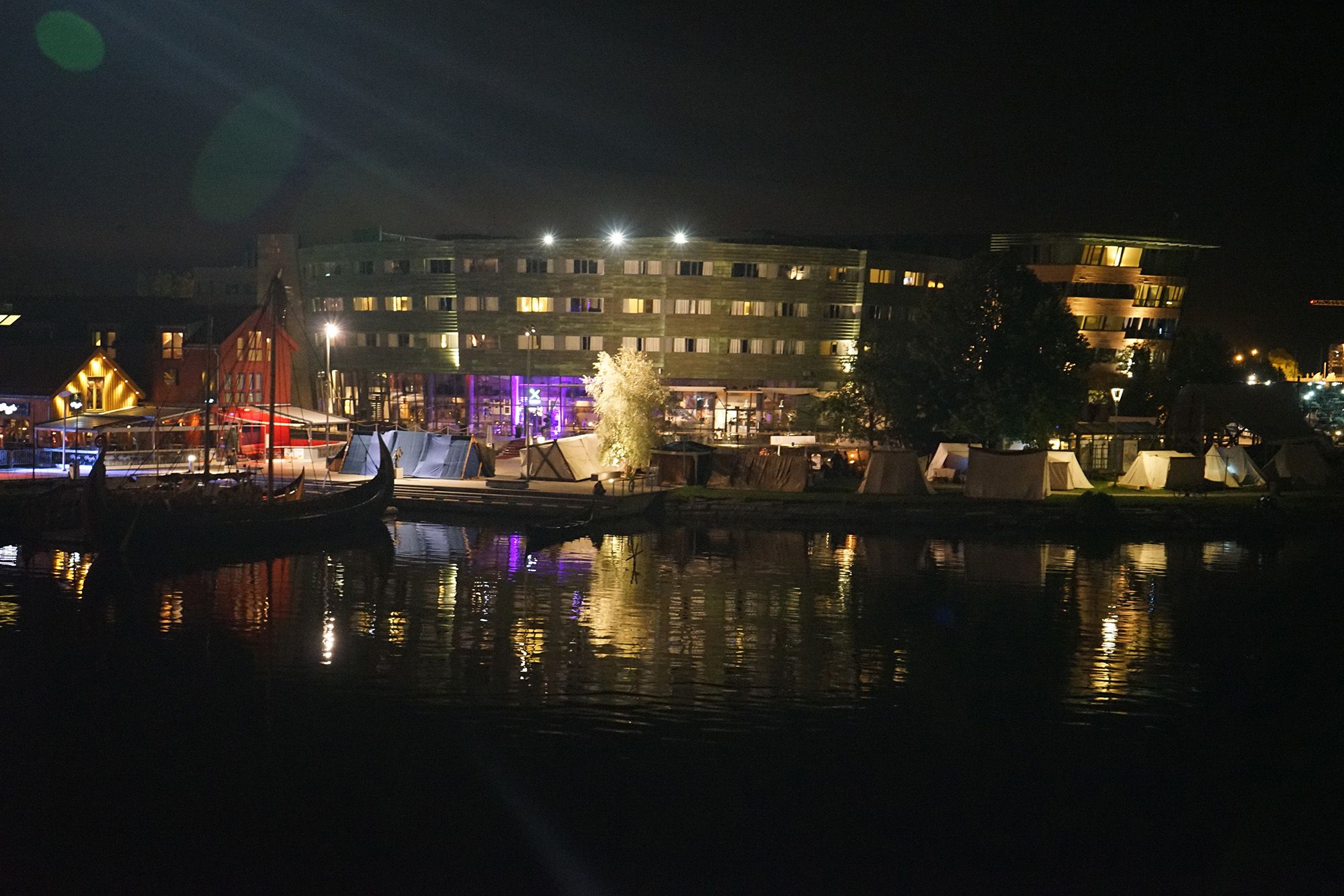 The Viking ship Saga Oseberg on the pier in Tønsberg in the evening while the town lights up