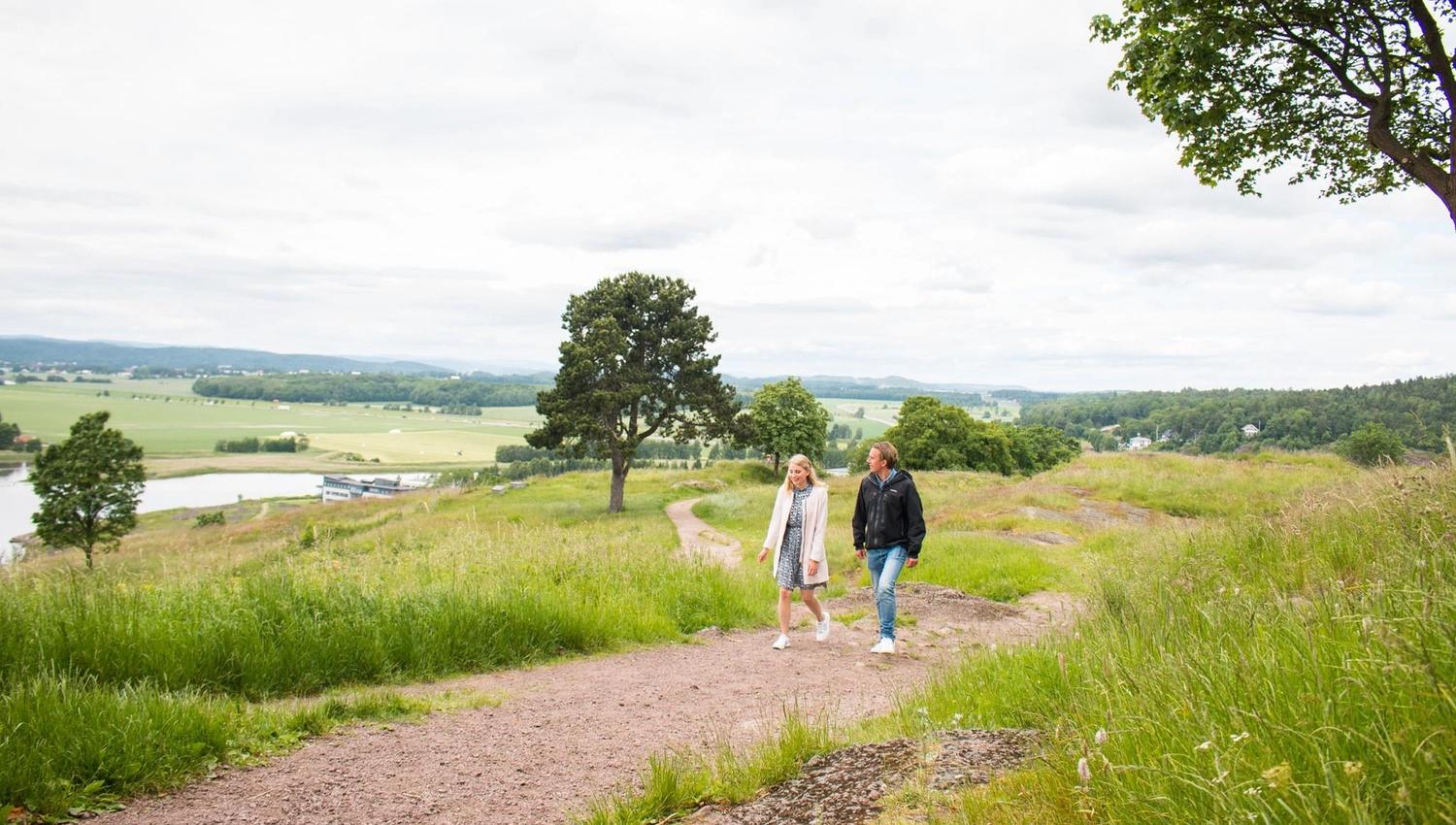 To mennesker vandrer på området til Slottsfjelltårnet