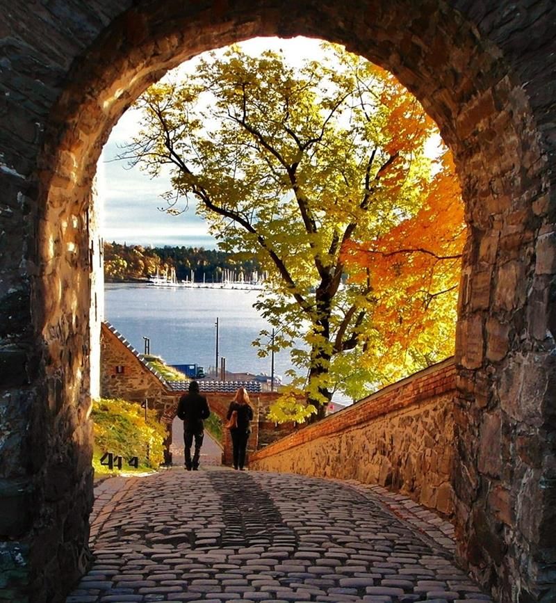 Høstbilde av to mennesker som går langs festningen.