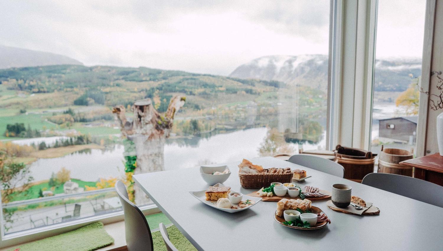Eit bord fylt med lokal mat frå Hardanger med panoramautsikt over fjordlandskapet.