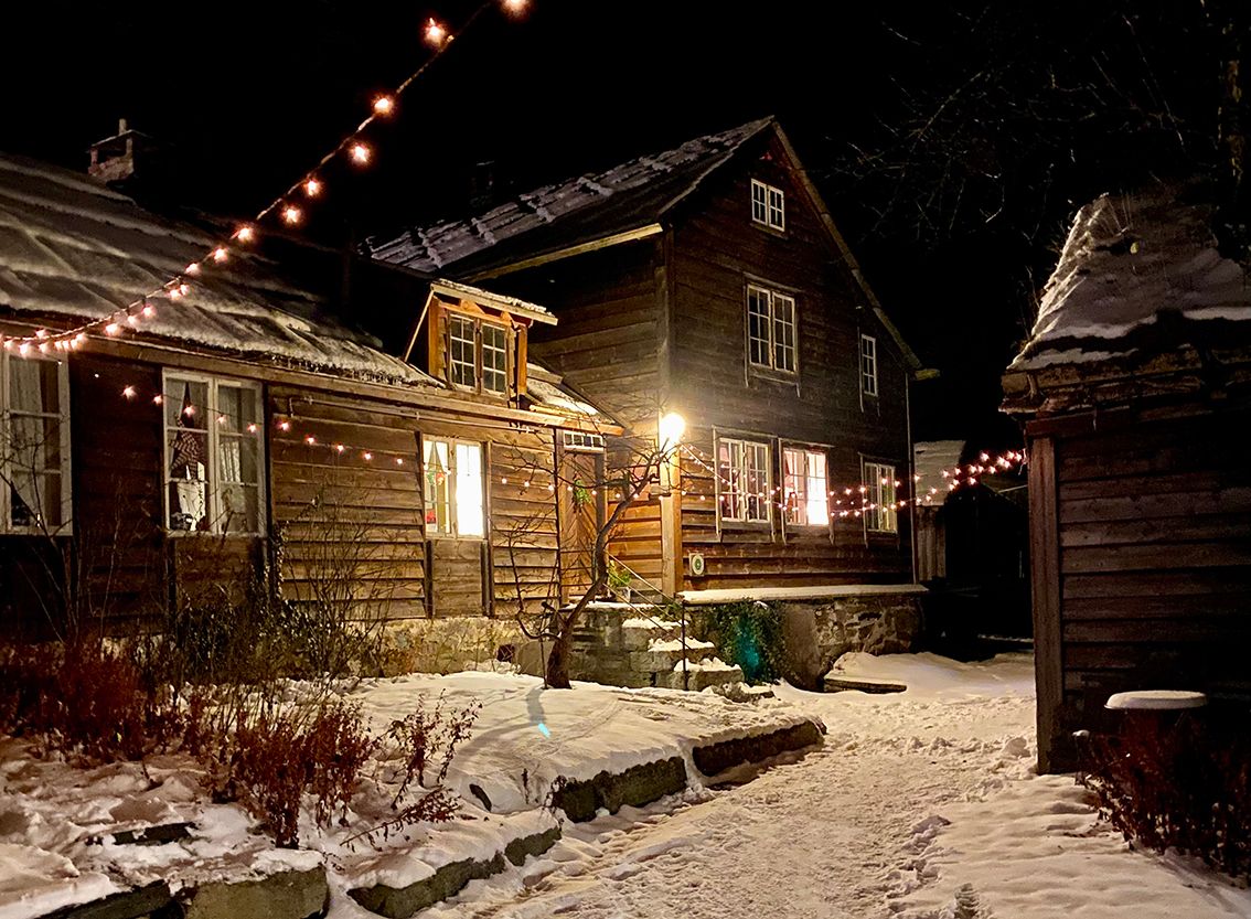 Ein bygning i tunet kledd i snø og julelys