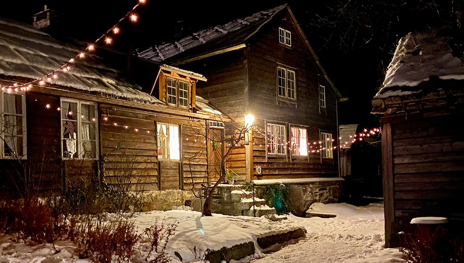 Ein bygning i tunet kledd i snø og julelys