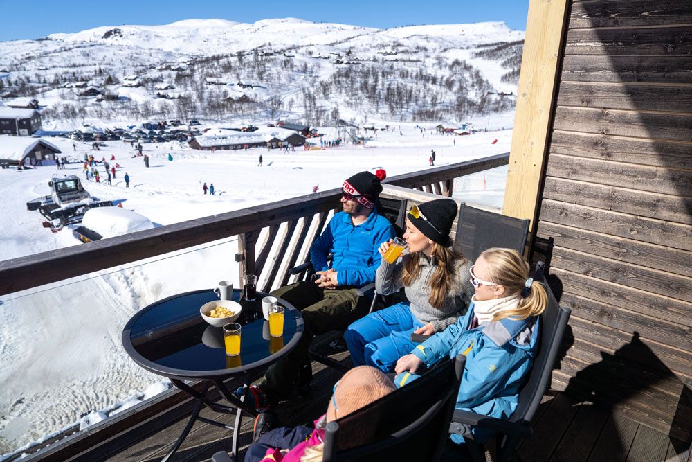 familie sitter på balkong på leilighet på Haukelifjell skisenter