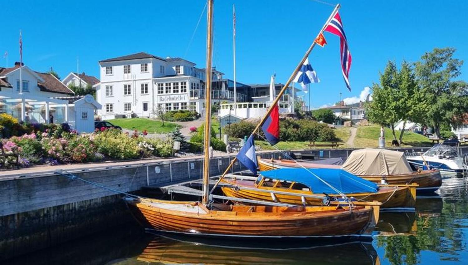 Trebåter på vannet foran Badehotellet, blå himmel