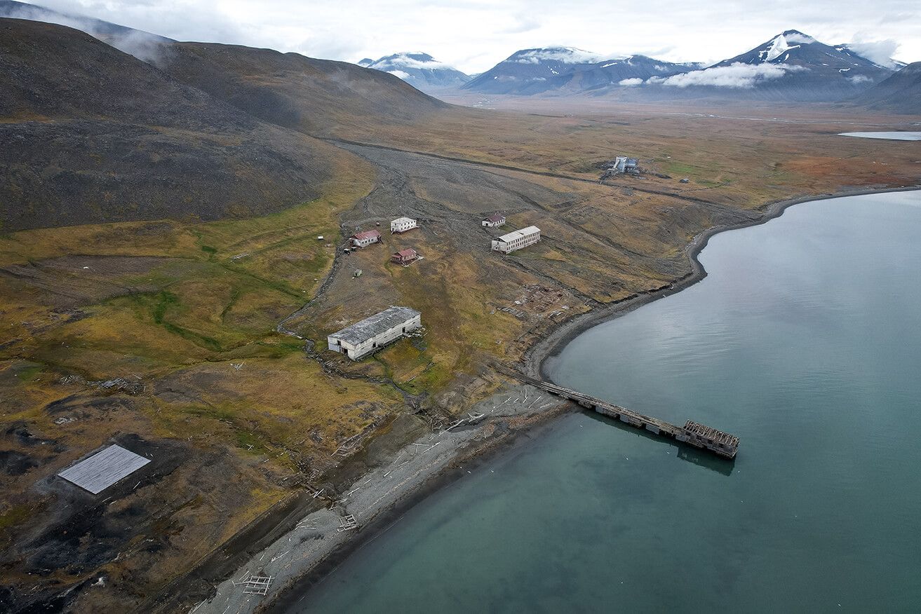 Abandoned buildings in an old settlement next to a fjord