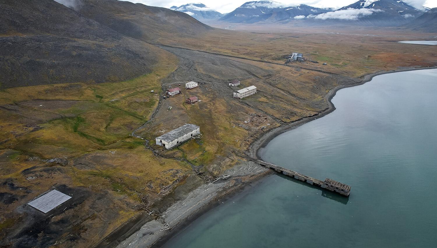 Abandoned buildings in an old settlement next to a fjord