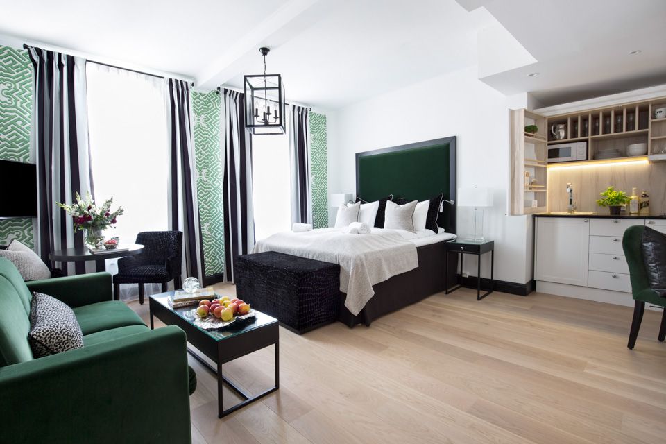 Leilighet på Frogner House Apartments. Seng, sofa og kjøkkenhjørne. Foto