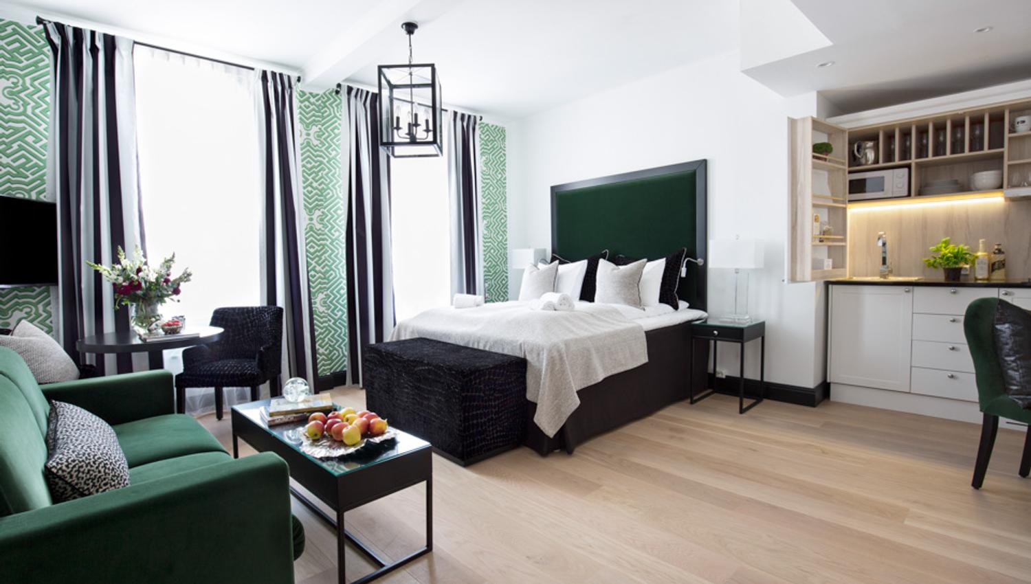 Leilighet på Frogner House Apartments. Seng, sofa og kjøkkenhjørne. Foto