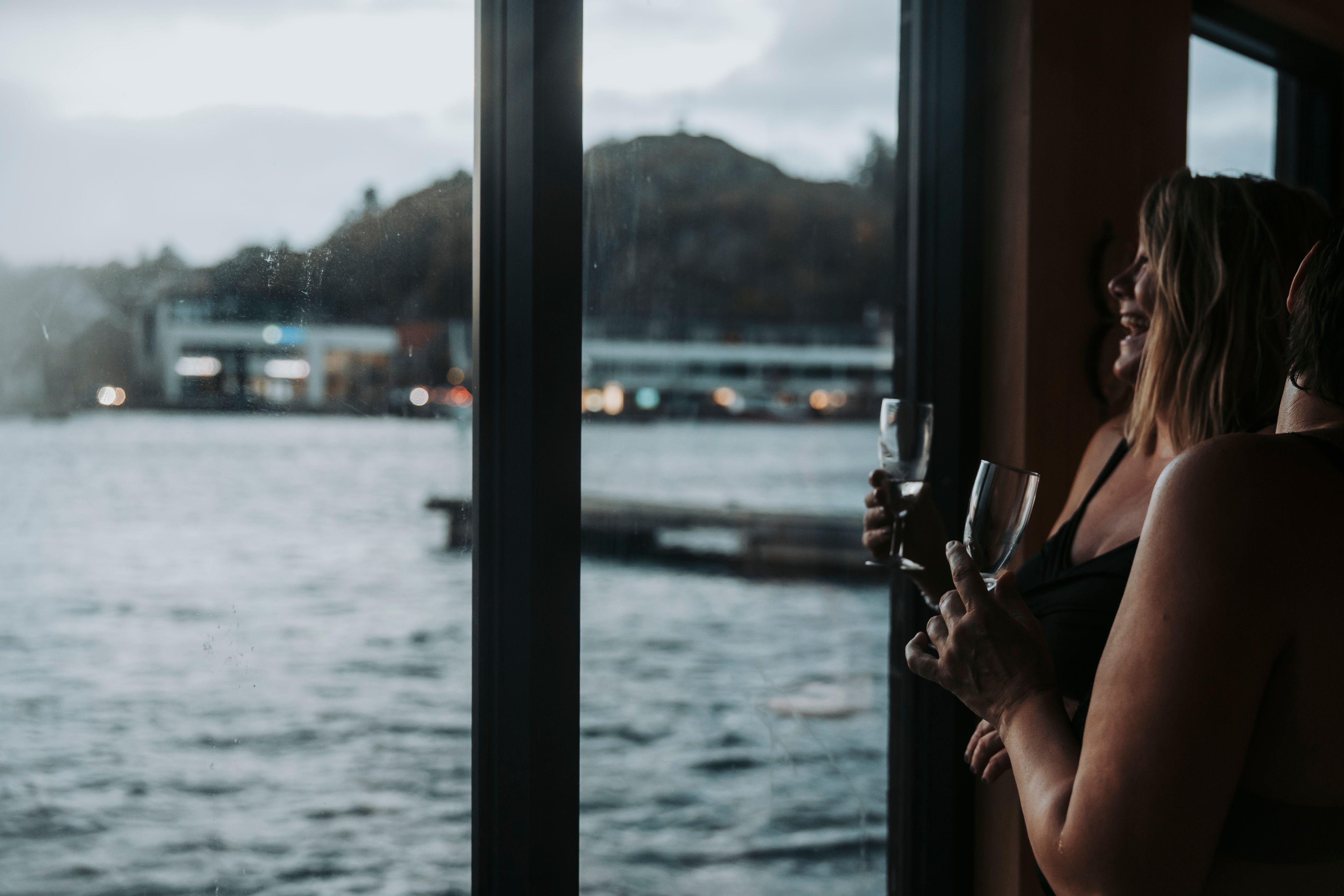 To damer som koser seg med noe godt i glasset i badstubåten Pysen