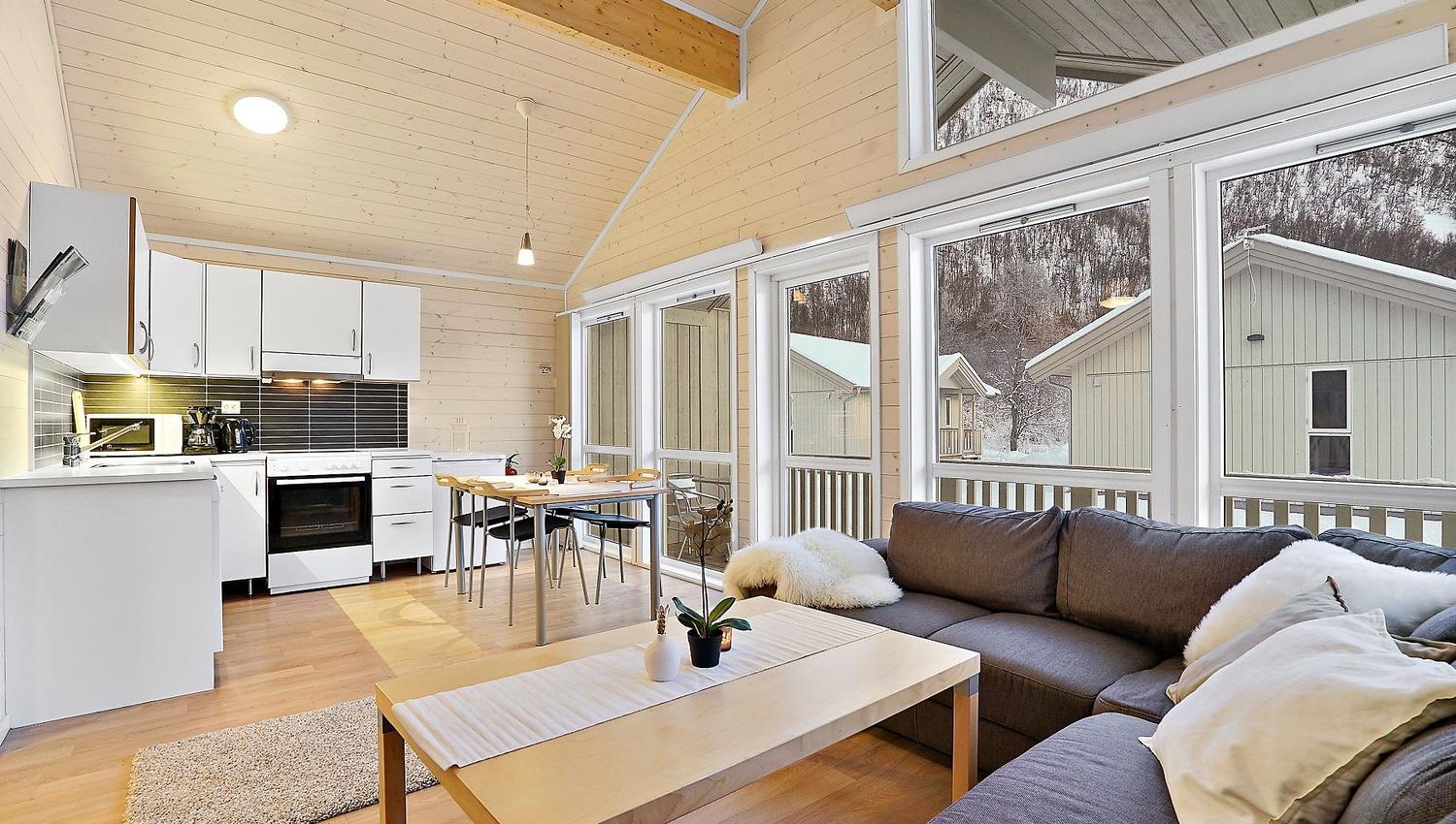 Open-plan living room with kitchen, dining table, and sofa, bright and modern interior