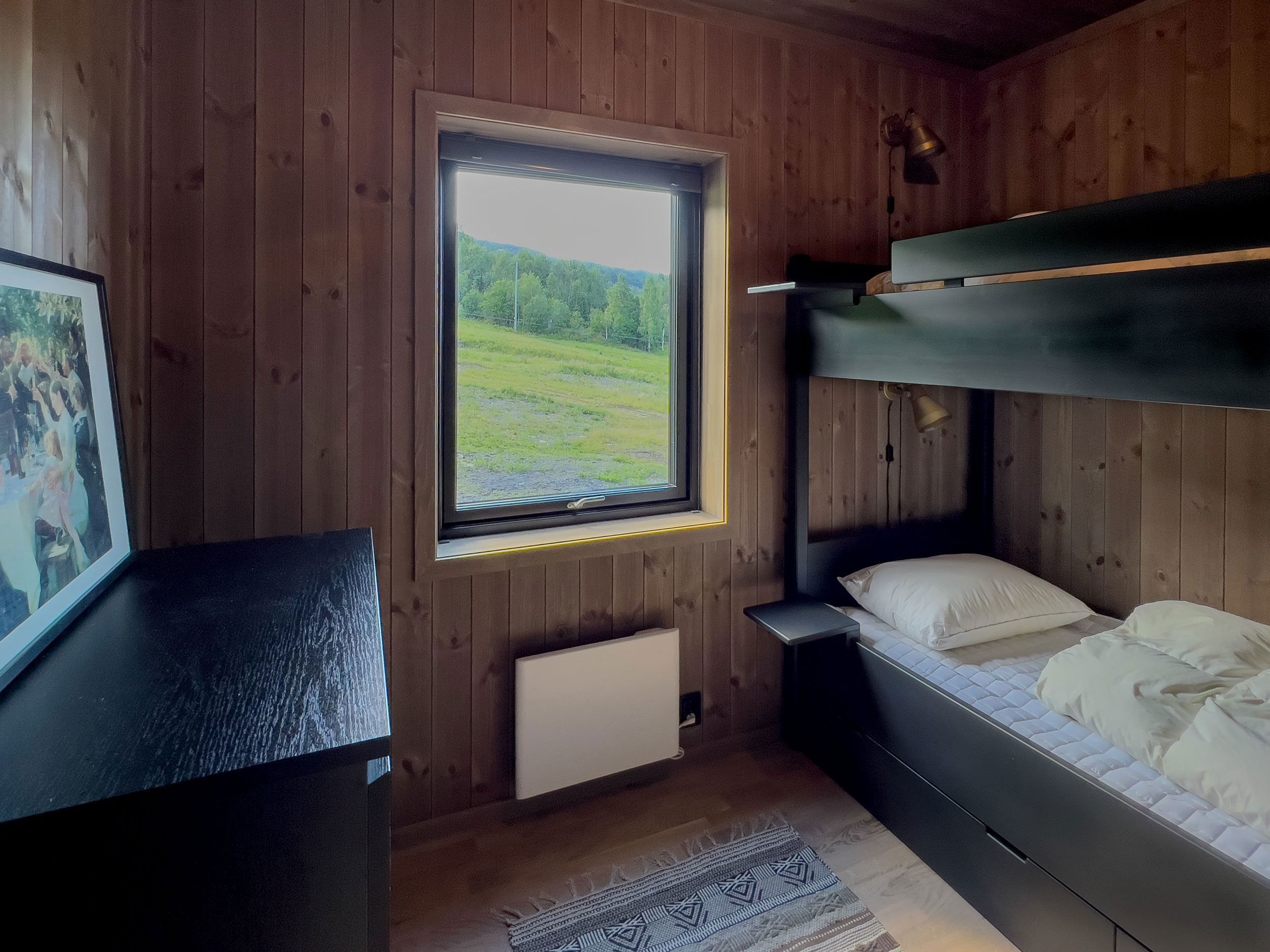 A bunk bed in a room with a window.