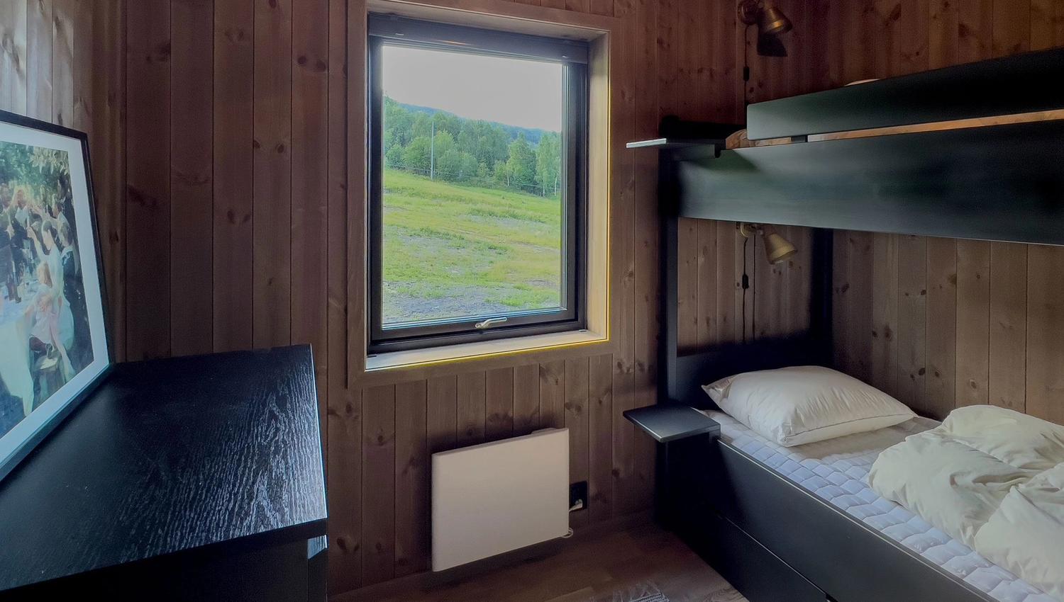 A bunk bed in a room with a window.