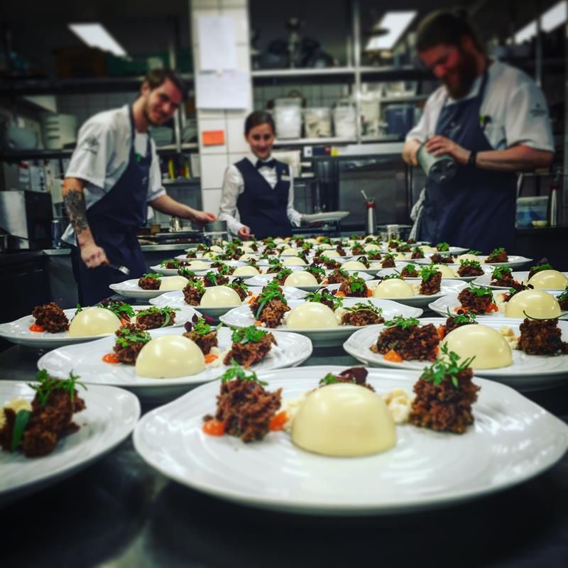 Kjøkkenpersonale forbereder gourmetretter. Foto