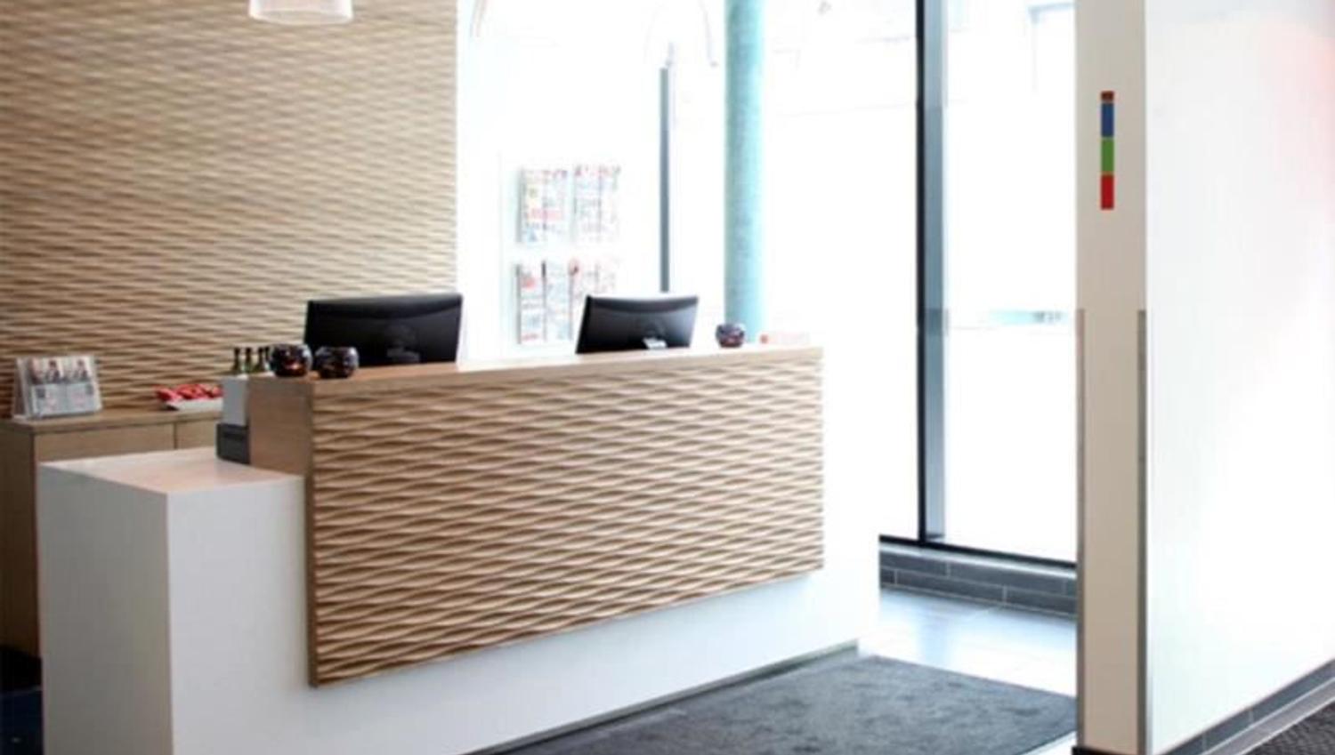 Modern reception area with a wooden front, large windows, and pendant lights.