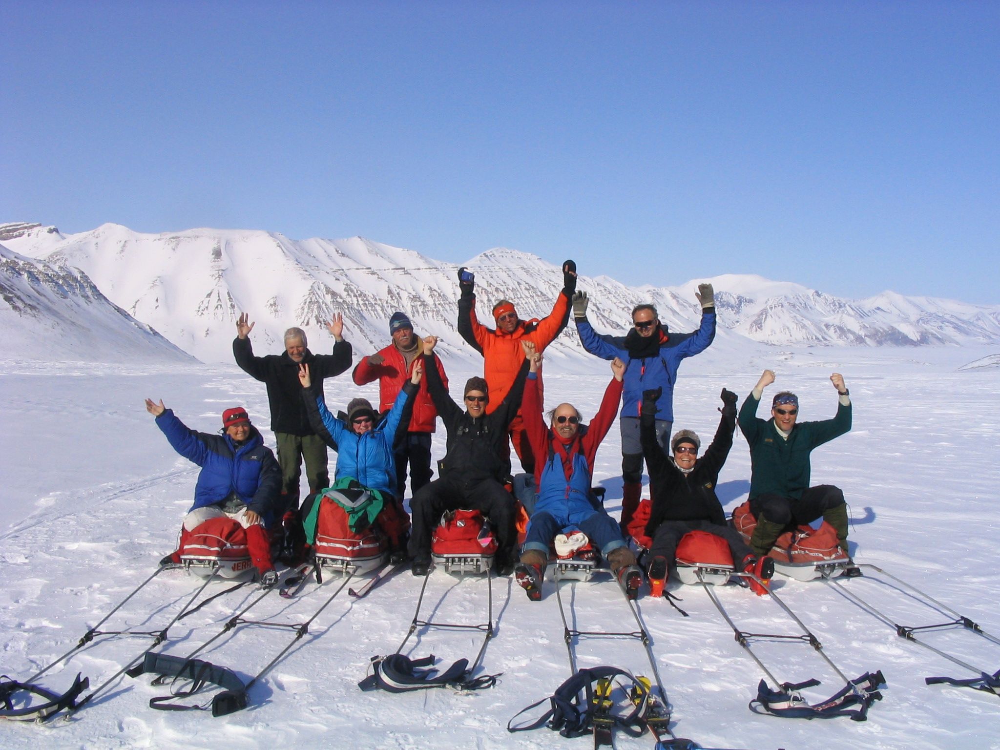 En turgruppe som poserer for kamera på pulkene sine