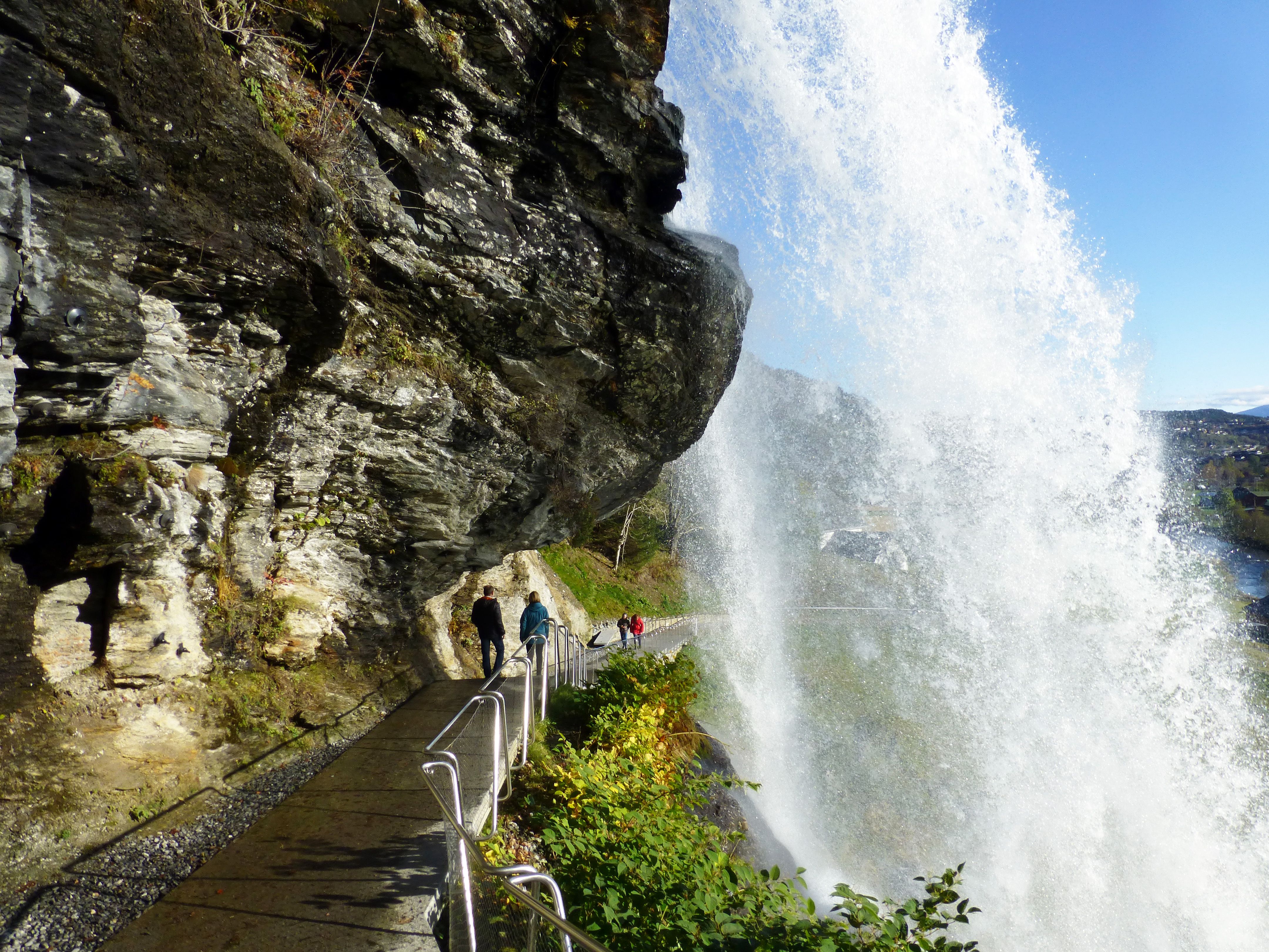 Besøkande går bak den mektige Steinsdalsfossen på trygg sti, eit av dei mest kjende landemerkene i Hardanger.