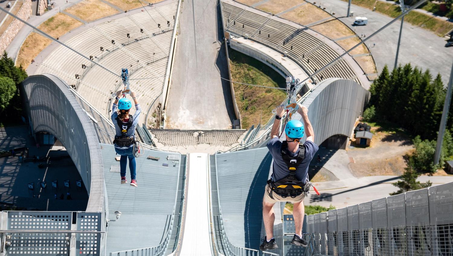 To personer som zipliner nedover Holmenkollbakken.