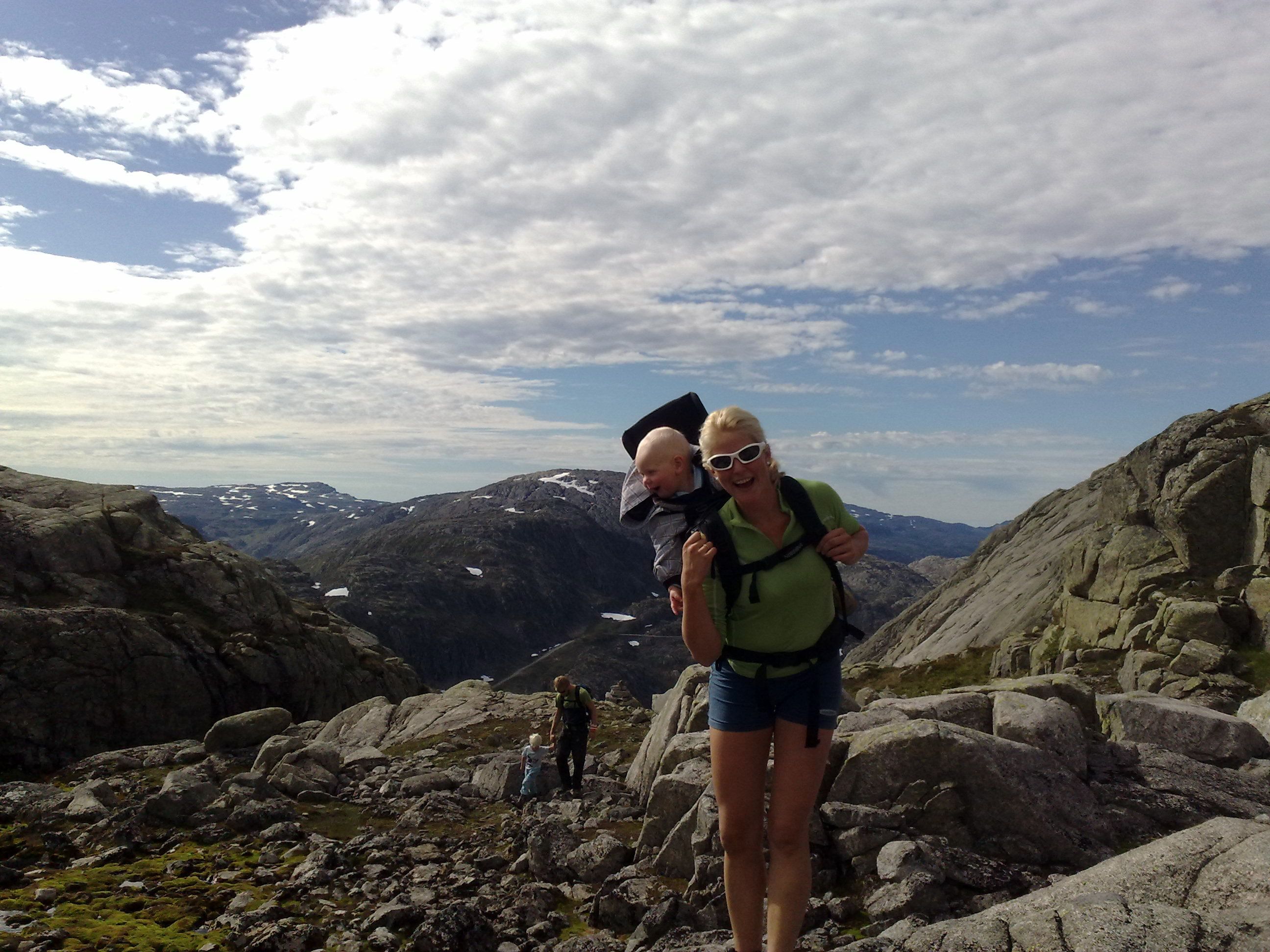Familie på fjelltur til Røldalssåto under klar himmel, omgitt av storslått natur og vidder.