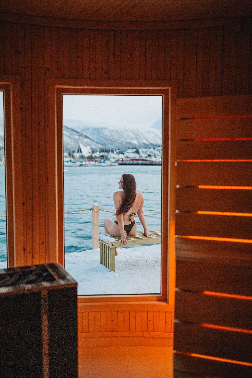 En person sitter utenfor badstua