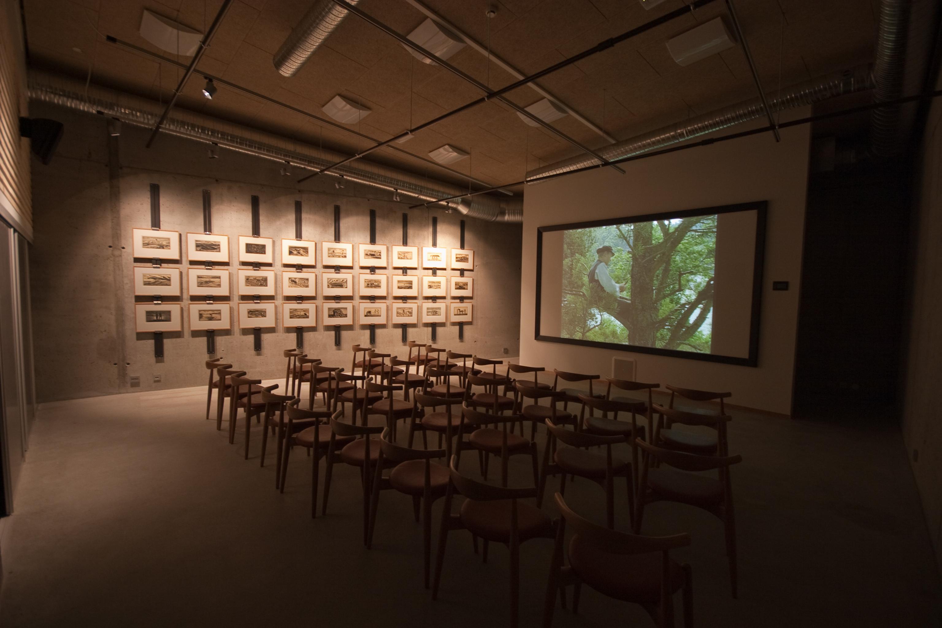 Room with many chairs facing a large screen