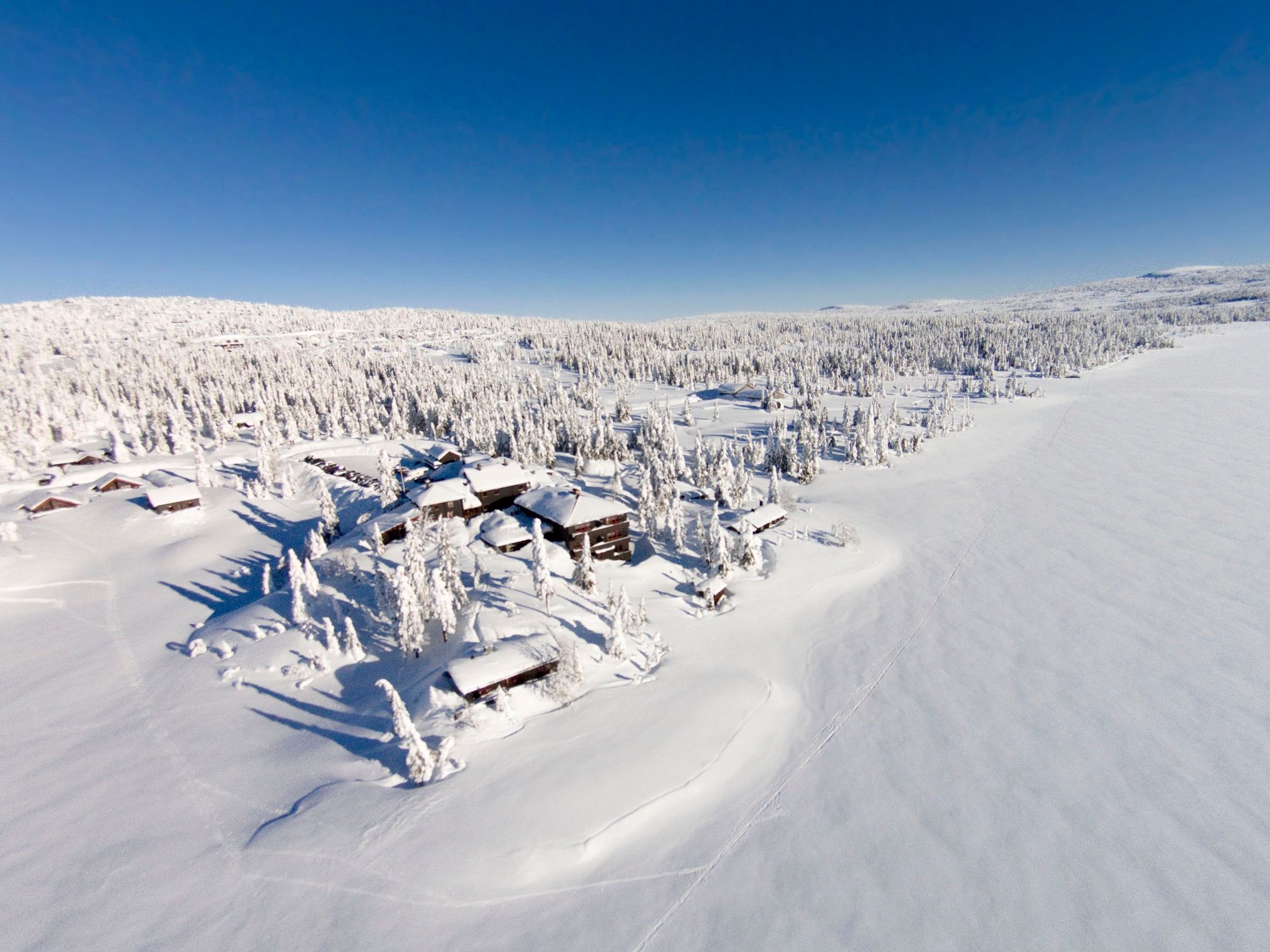 Dronebilde av snødekket Rustad hotel & Fjellstue