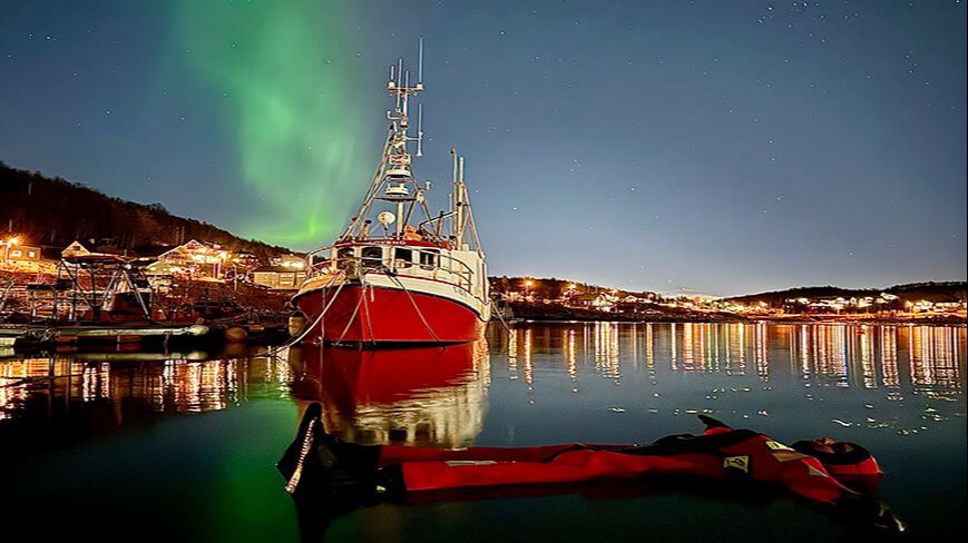En gjest som flyter i vanner under nordlyset