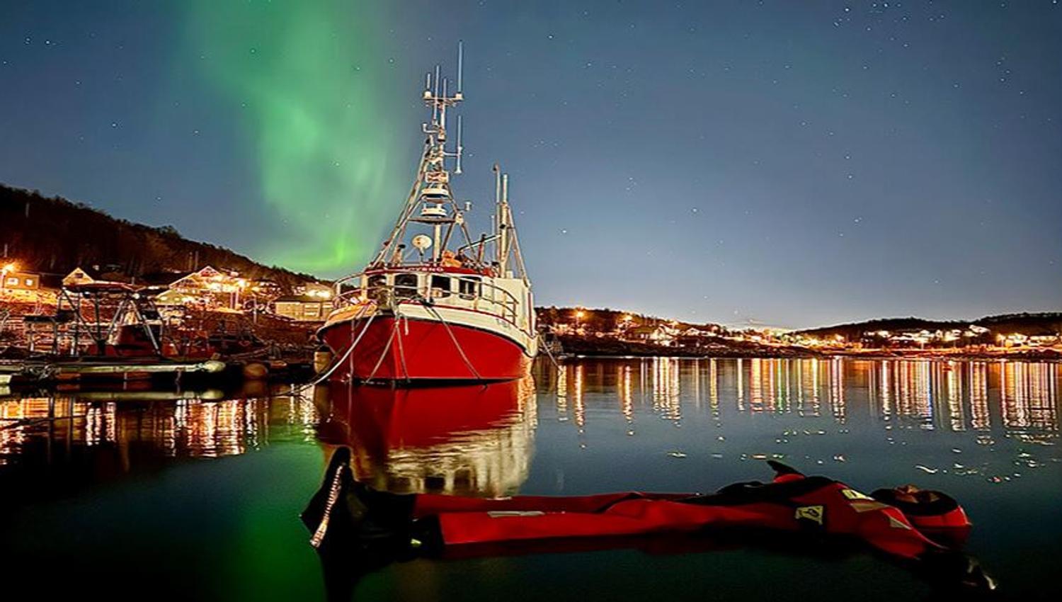 En gjest som flyter i vanner under nordlyset
