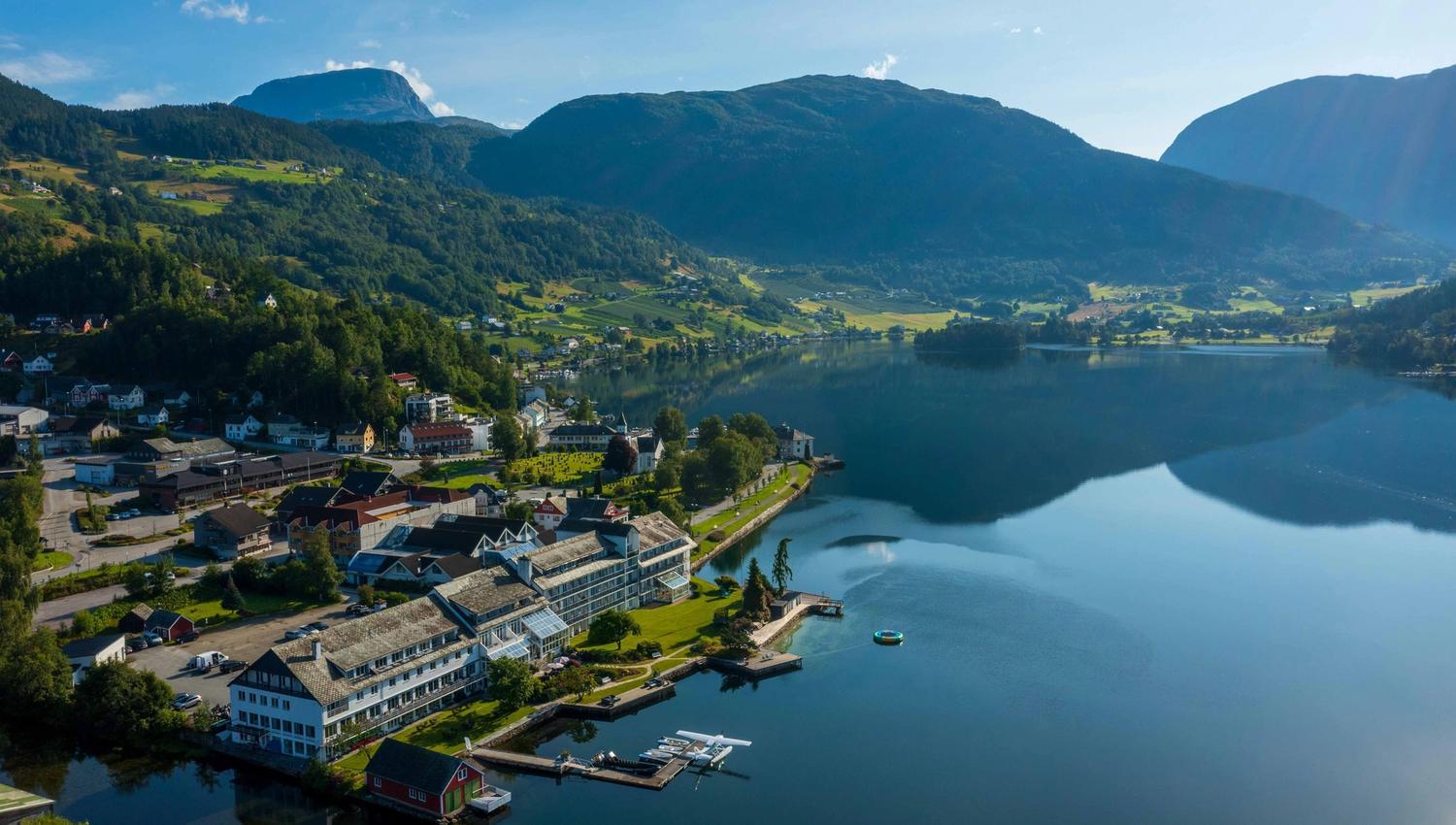 Luftfoto av Brakanes Hotel i Hardanger, med utsikt over fjord, fjell og vakre omgjevnader.