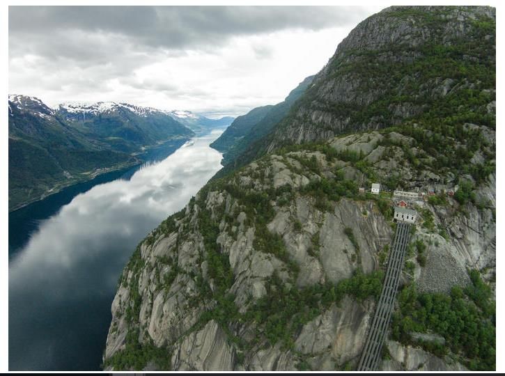 Flyfoto av Lilletopp, med dei bratte fjellsidene og det ikoniske rørsystemet ned mot fjorden.