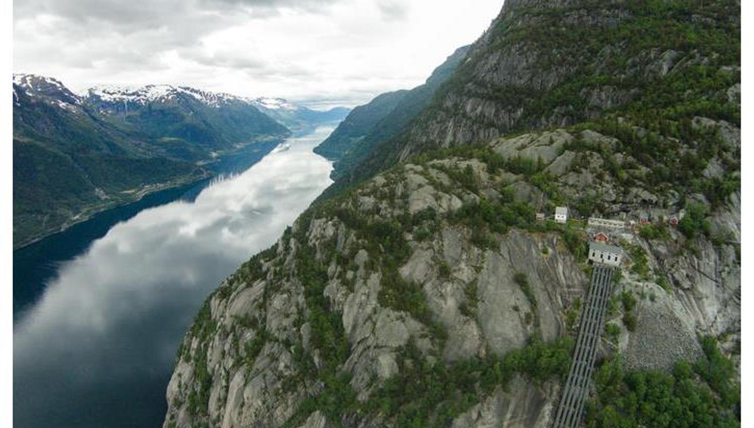Flyfoto av Lilletopp, med dei bratte fjellsidene og det ikoniske rørsystemet ned mot fjorden.