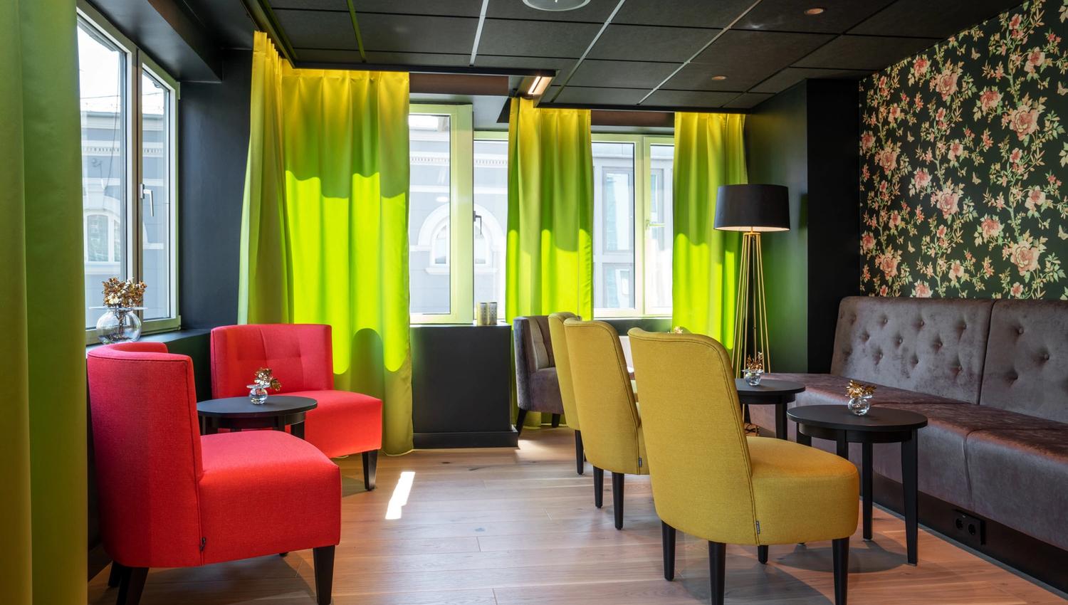 Sittegrupper i rødt og grønt i lobbyen. Thon Hotel Gyldenløve. Foto
