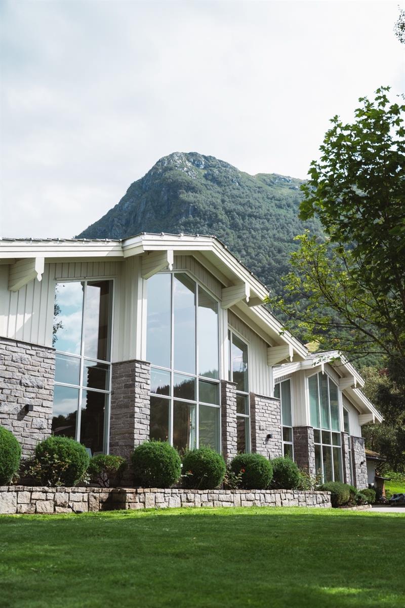 Fasaden til Rosendal Fjordhotel med fjellandskap i bakgrunnen