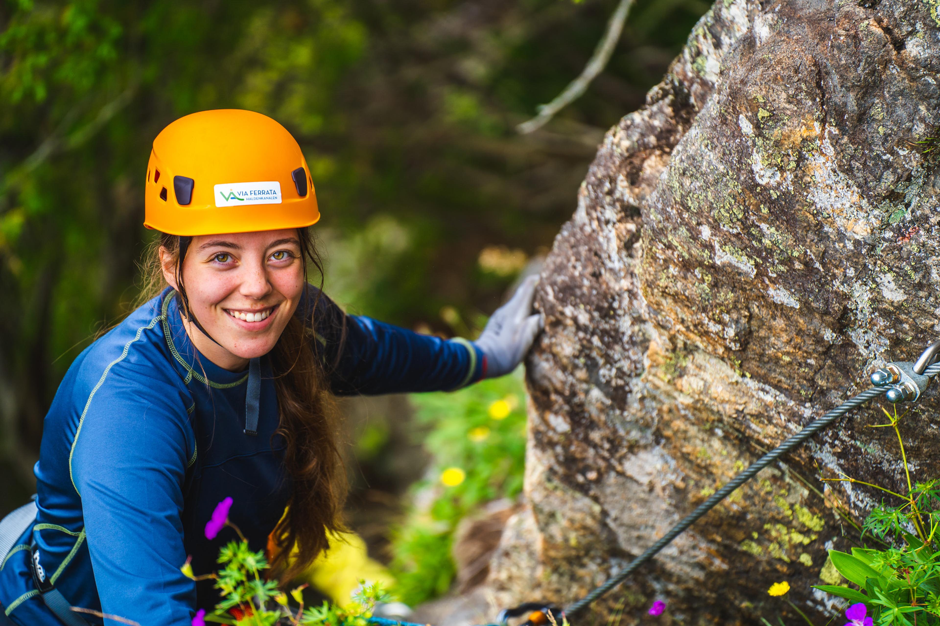 Jente i klatreløypa på vei opp fjellet i Via ferrata Haldenkanalen