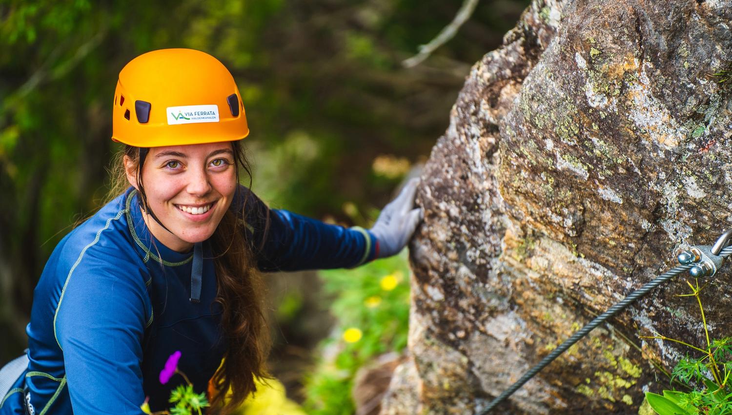 Jente i klatreløypa på vei opp fjellet i Via ferrata Haldenkanalen