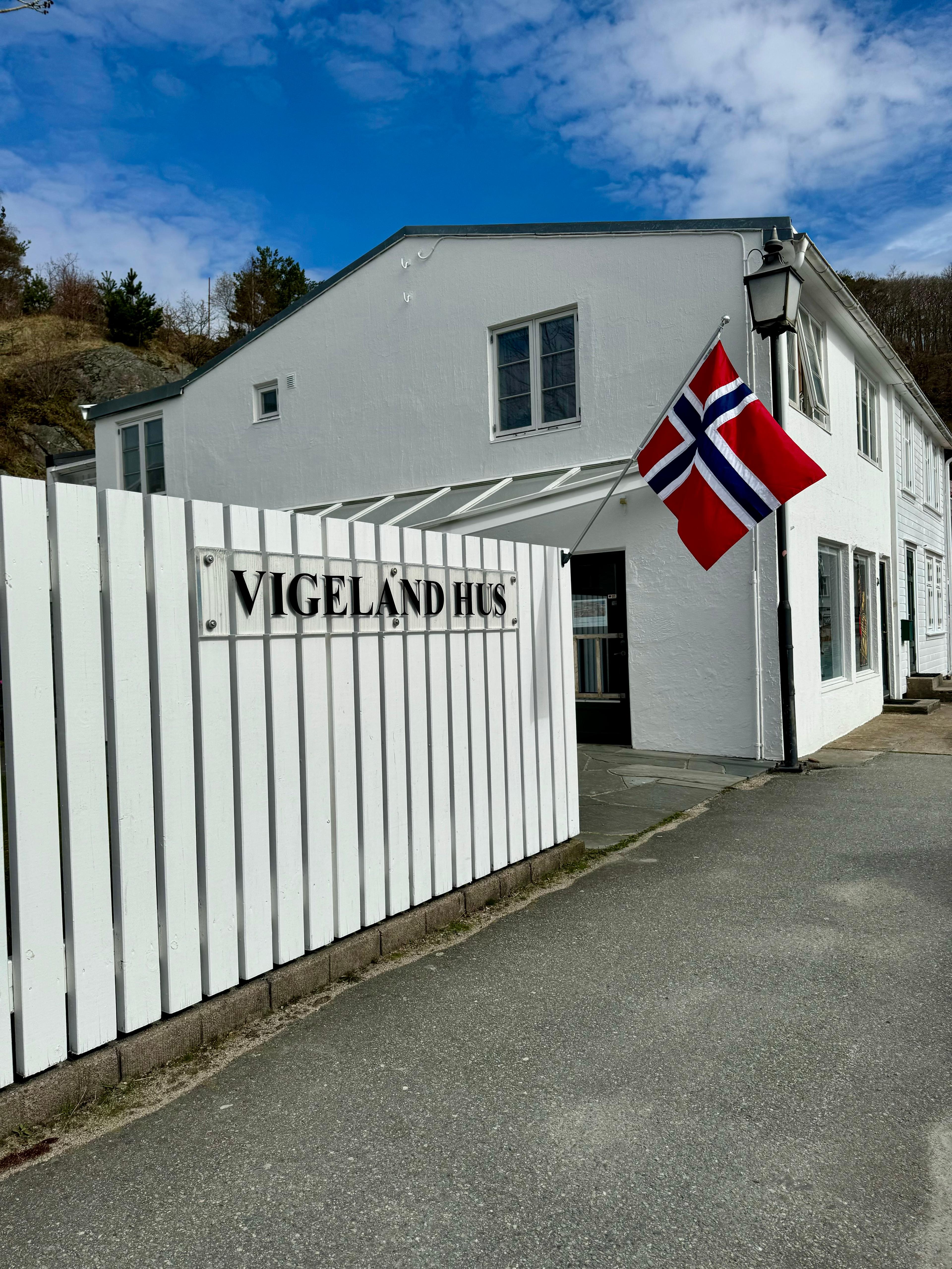 Facade of Vigeland House, with the Norwegian flag on the pole.