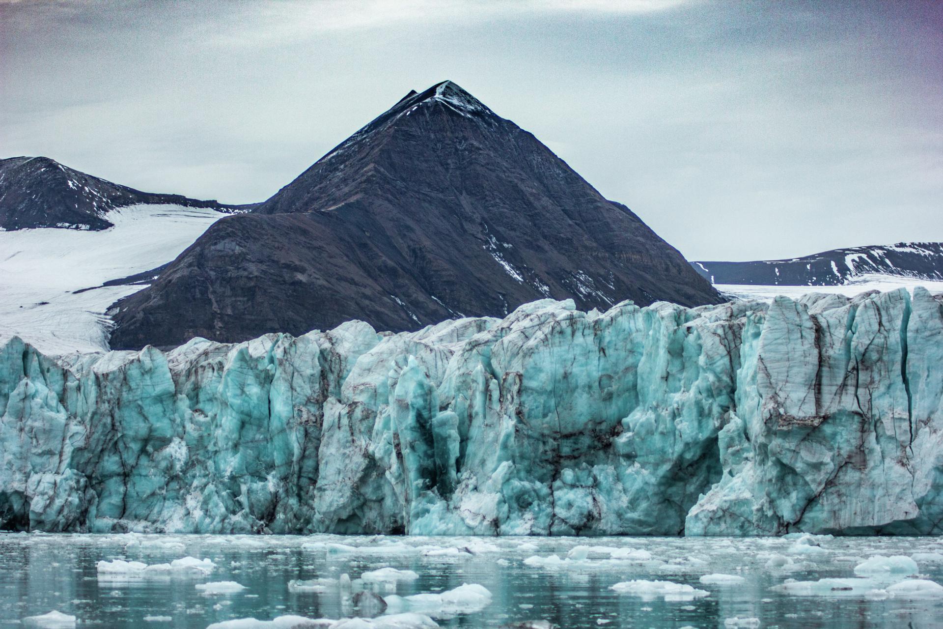 Floating ice in a fjord with glacial walls rising up towards the mountains