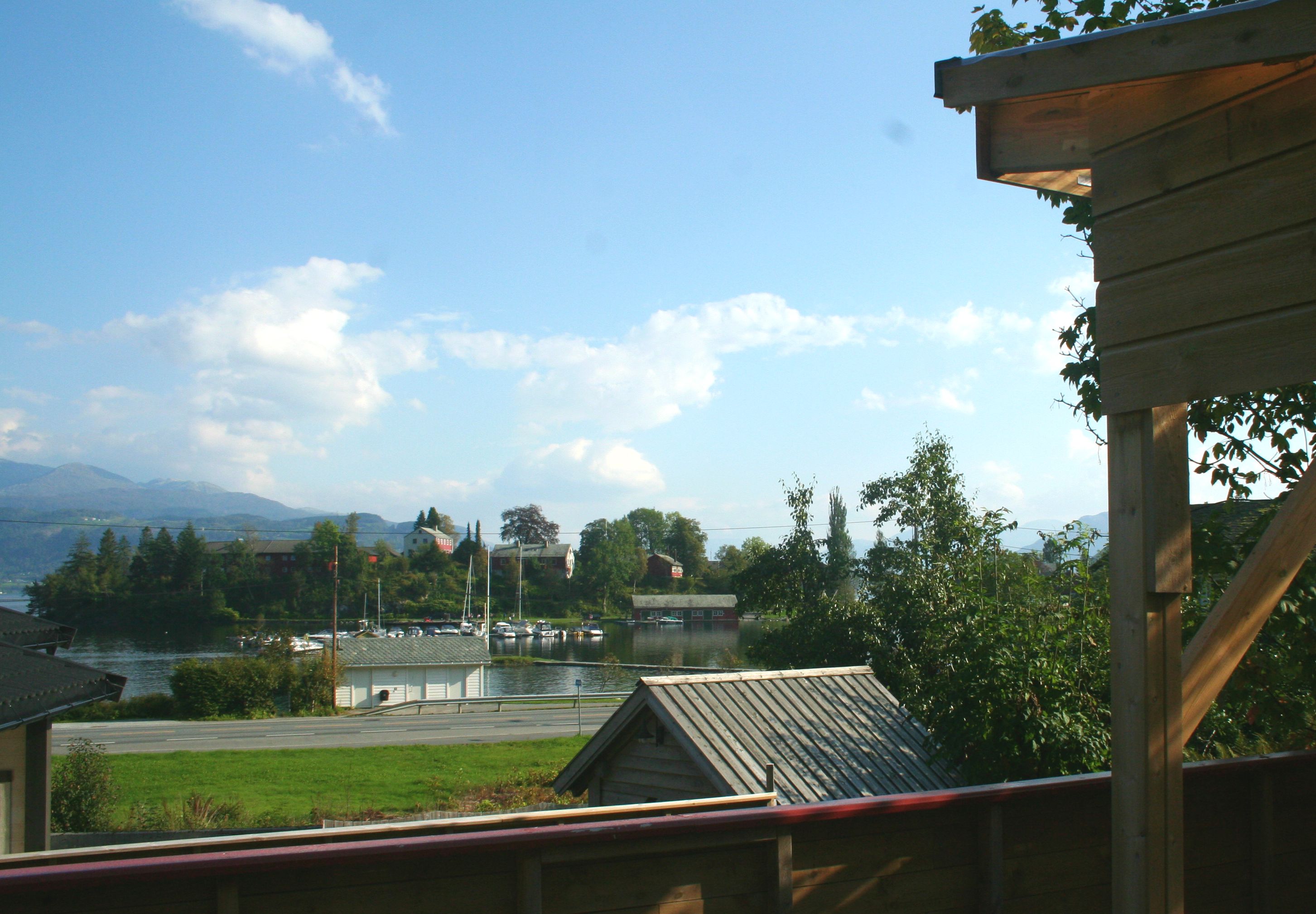 Vakker utsikt frå verandaen mot fjorden og nærliggande småbåthamn ved Vågen Rom og Hytteutleige i Hardanger.