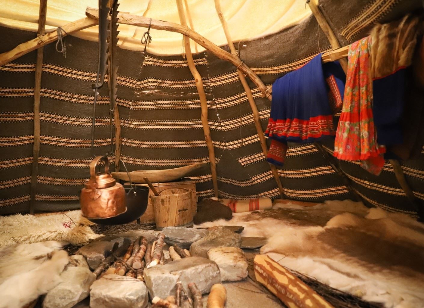 Ulike samiske gjenstander og håndverk vises frem på innsiden av gammen i basisutstillingen.