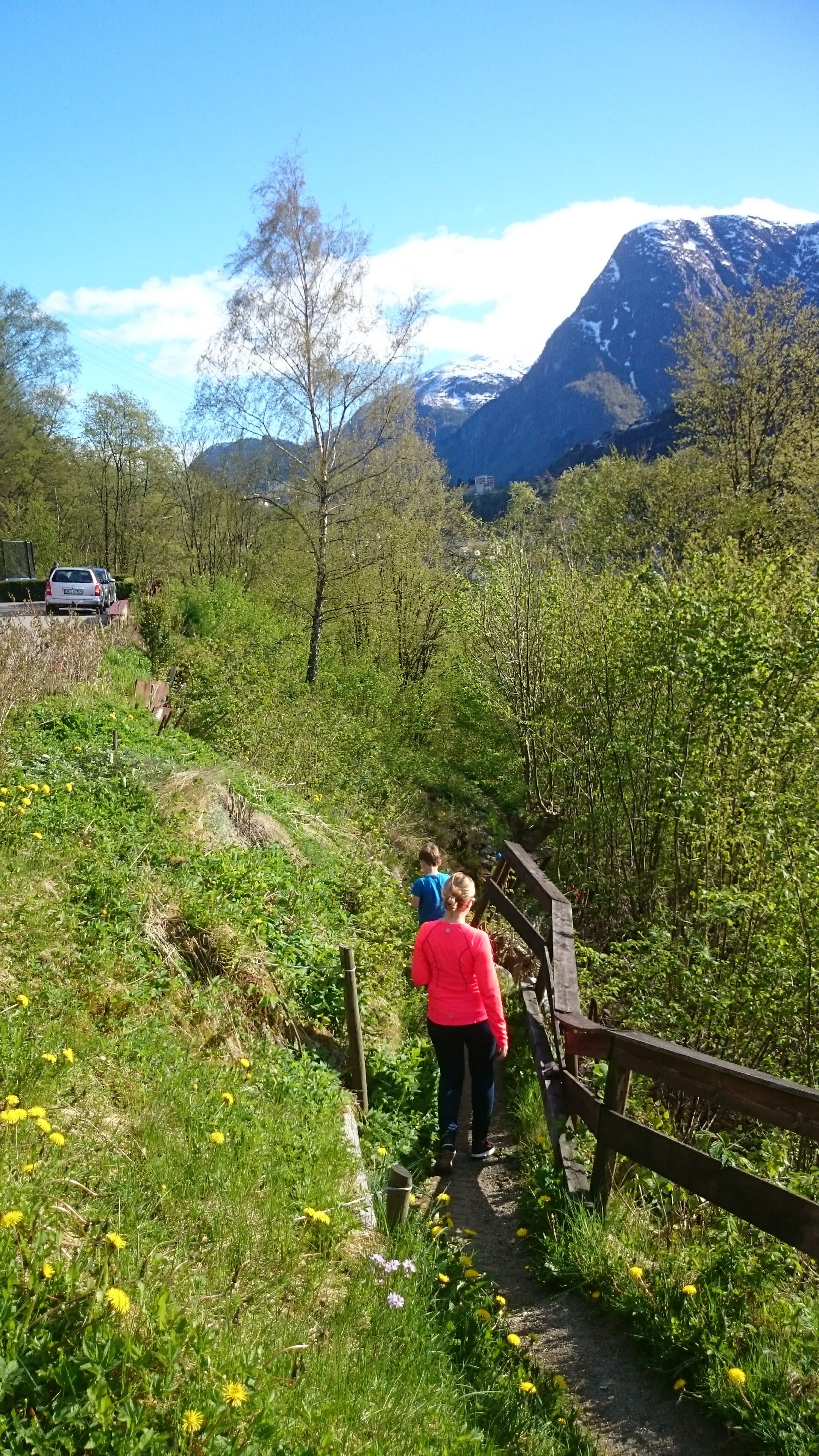 Ein familie på vandring langs kulturstien Hjøllo–Mannsåker i Hardanger ein solrik vårdag.