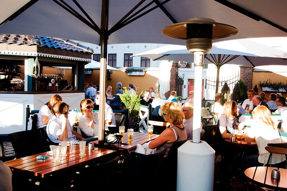 Uteservering under parasoller.