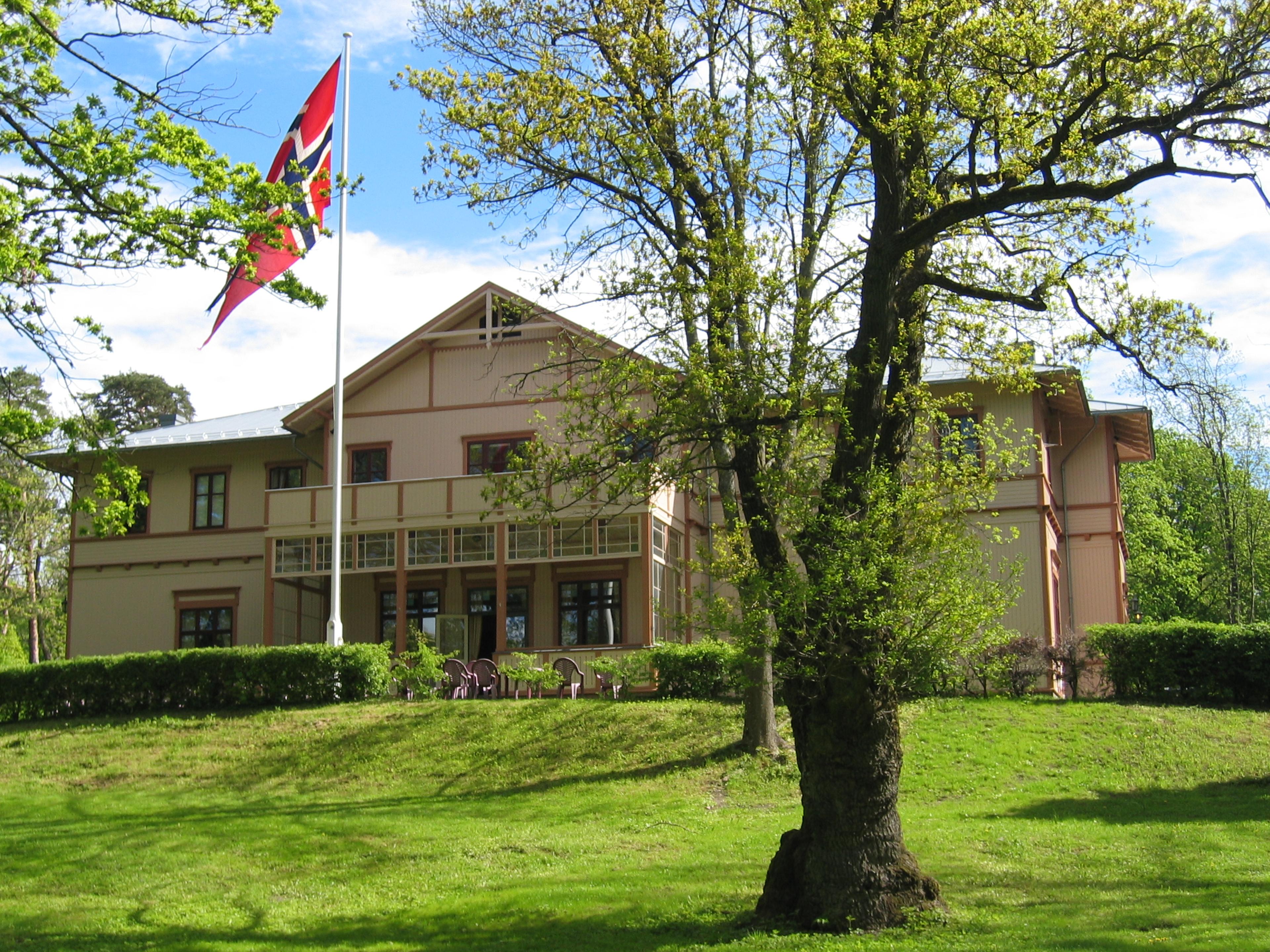 The hotel with a green lawn and a flagpole in the foreground.
